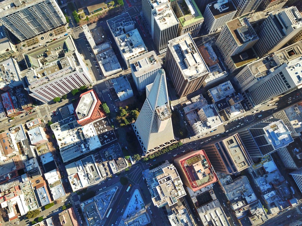 A bird's-eye view of the downtown San Francisco skyline, with the Transamerica Pyramid skyscraper prominently featured in the center.